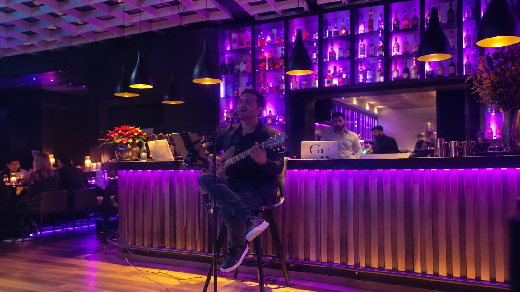 Sänger mit Gitarre vor der violett beleuchteten Bar des Âu Lac